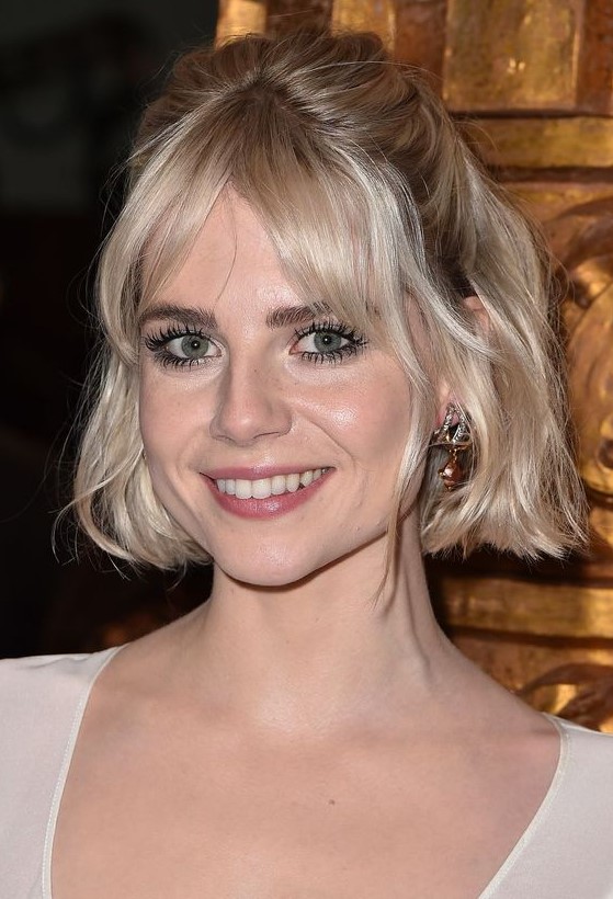 a platinum blonde chin length bob with curtain bangs and waves styled as a half updo is a catchy idea