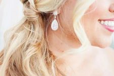 a pretty and easy blonde knot side ponytail and waves framing the face are a simple and cool idea for a wedding