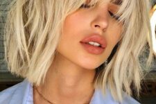 a pretty and trendy long bob haircut of cool vanilla tone and with bangs and messy waves is amazing for summer