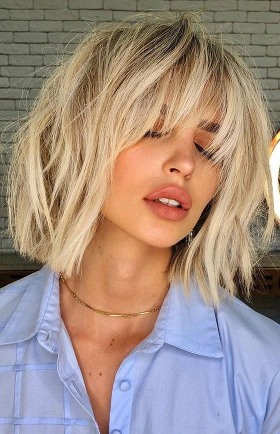 a pretty and trendy long bob haircut of cool vanilla tone and with bangs and messy waves is amazing for summer