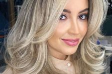 a pretty blonde medium-length butterfly haircut with wavy ends and a lot of volume is a lovely idea, and this cold shade of blonde is chic