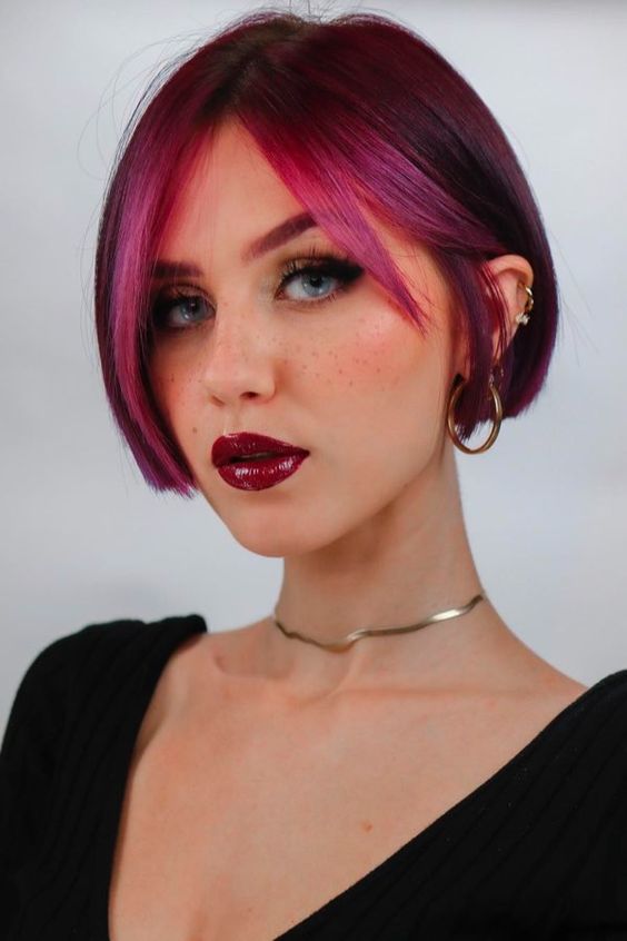 a purple ear length bob with a hot pink money piece is a fantastic statement with color