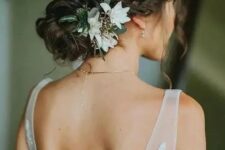 a refined wedding low bun with twists and a braid, with white blooms will match a fall and a summer wedding