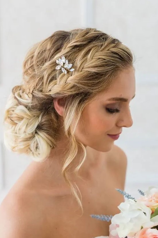 a romantic braided side chignong with several braids on top, some waves down and a crystal hairpiece