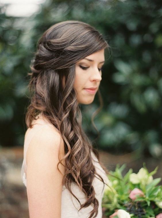 a romantic wavy side half updo with waves down and on top is a cool idea for many bridal outfits