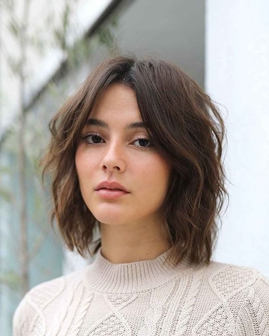 a shaggy and layered brown long bob with curtain bangs and central parting is a cool and very up to date idea to try right now