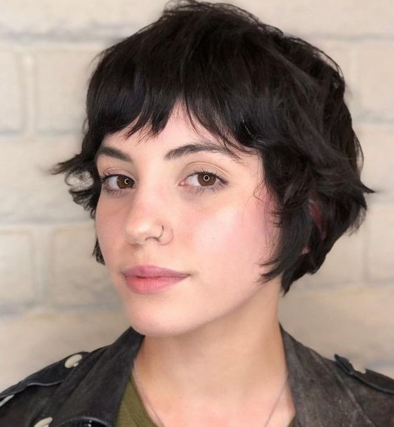 a shaggy black ear-length bob with bottleneck bangs and waves is a cool idea that looks effortless