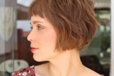 a shaggy ginger ear-length bob with mesys bangs and a lot of volume is a catchy and chic idea to try