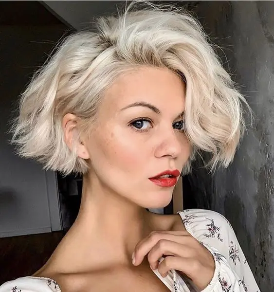 a short bleached ear length bob with a lot of volume and waves looks very chic and lovely