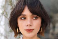 a short brunette bob with a lot of volume and bottleneck bangs plus a slight ombre touch