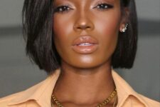 a stylish and catchy shiny black midi bob with side part and a lot of volume looks incredibly chic and bold