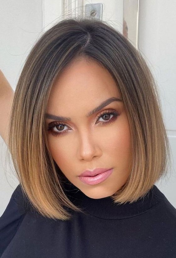 A stylish and elegant brunette chin length bob with an ombre effect with a caramel shade and side part
