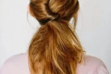 a twisted and textural low messy ponytail with a volume on top and some locks framing the face for a casual bridal or bridesmaid look