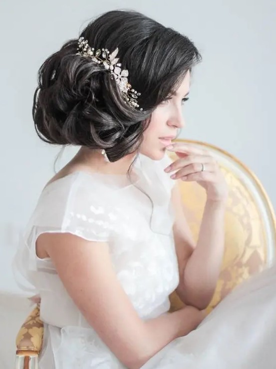 a voluminous curly side updo with some locks down and a statement embellished floral hairpiece that rocks
