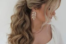 a voluminous wavy ponytail with a bump on top and face-framing hair is adorable for most bridal styles