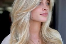 a warm sandy butterfly haircut with bleached blonde balayage on top and a bit of volume looks stylish and pretty