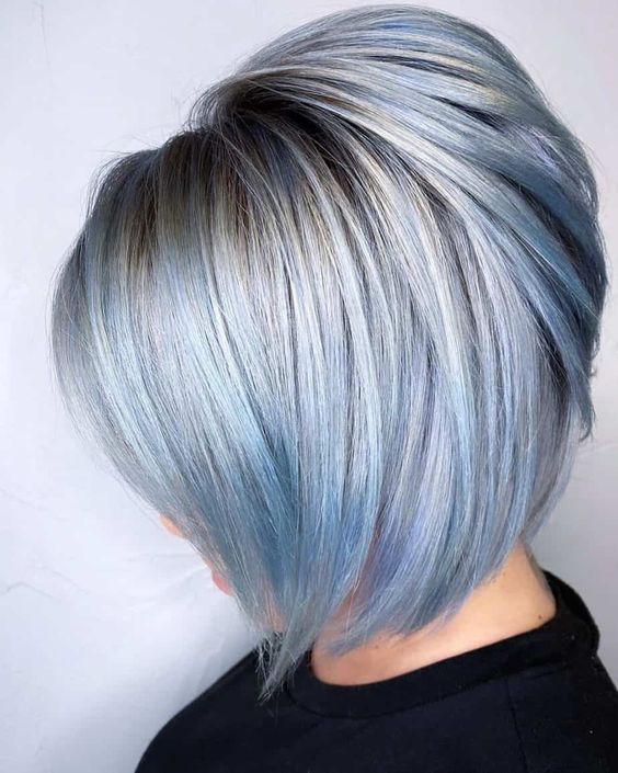 a washed out pastel blue A-line bob with silver root and a lot of volume looks cool and fresh