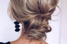 a wavy and chic low updo with a volume on top and some waves is a cool option for a modern refined bride
