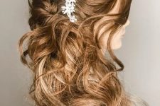 a wavy half updo with a dimensional top and waves around plus a rhinestone hairpiece is a gorgeous idea for a romantic bride
