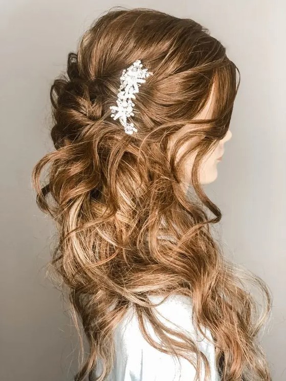 a wavy half updo with a dimensional top and waves around plus a rhinestone hairpiece is a gorgeous idea for a romantic bride