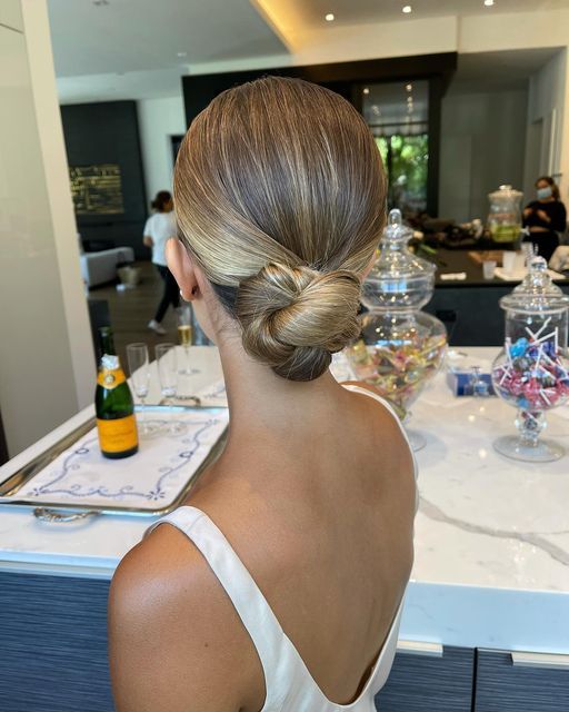 a woven low bun with a sleek top is a durable and comfortable for wearing updo that looks more interesting than a usual bun