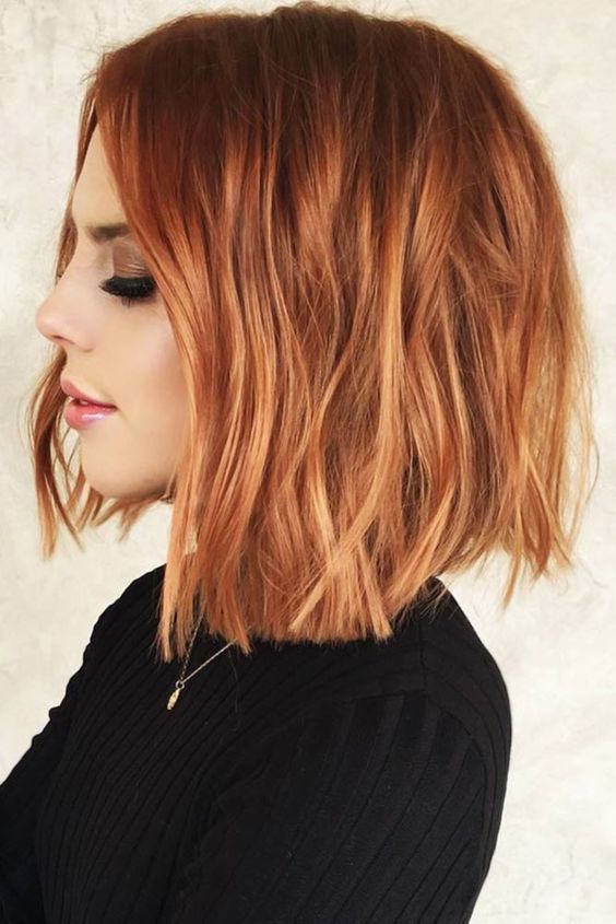 an edgy deep red long bob with copper red highlights and messy texture looks a bit grunge
