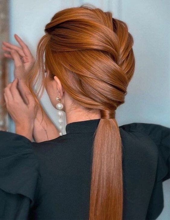 an elegant and chic low ponytail with a voluminous braided top and some waves down is perfect for a bridesmaid