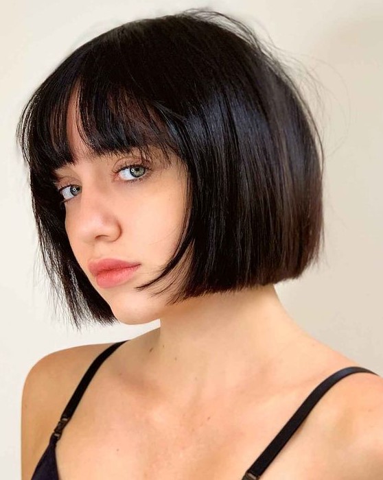 An elegant black chin length bob with wispy bangs is a classy idea, this length matches many face shapes, and bangs are airy