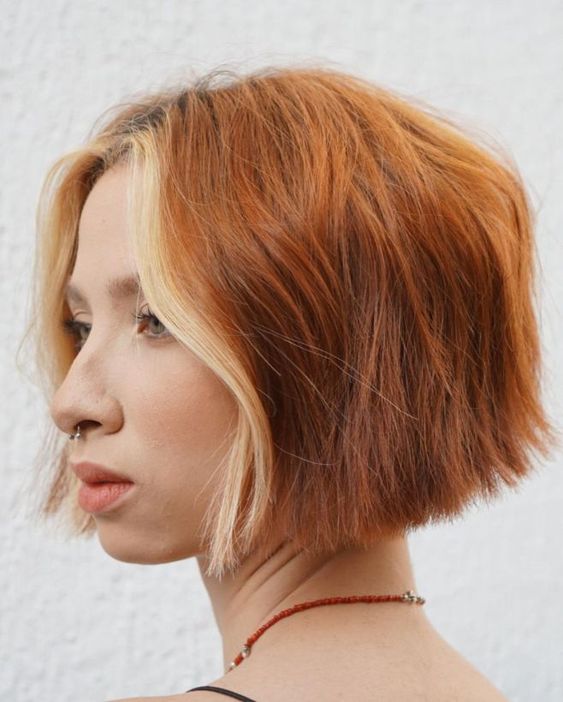 an eye catching copper red wavy chin length bob with a blonde money piece is a stylish and lovely idea