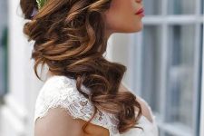 long brunette hair with a curly structure is side swept, accented with a flower crown, is a lovely solution for many brides