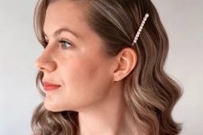 medium wavy hair can be styled side-swept, with a side part and a pearl hair pin is a cool solution for a modern bride