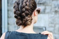 two voluminous braids with large low buns are a catchy and bold solution for a bridesmaid or a wedding guest