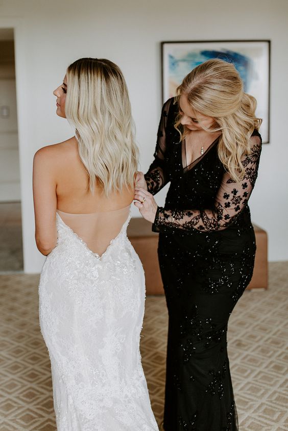 a black embellished mermaid mother of the bride dress with illusion sleeves, a V-neckline and a necklace are a lovely combo