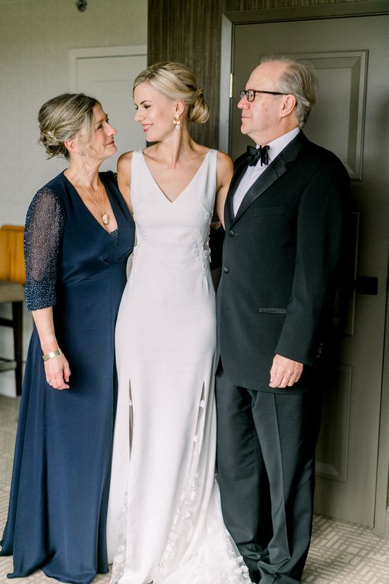 a midnight blue mother of the bride dress with aV-neckline, long sheer sleeves plus a statement necklace is a chic idea