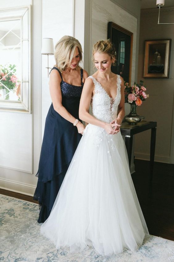 a navy maxi dress with an embellished neckline, straps, a tiered skirt is a stylish and chic idea for the mother of the bride