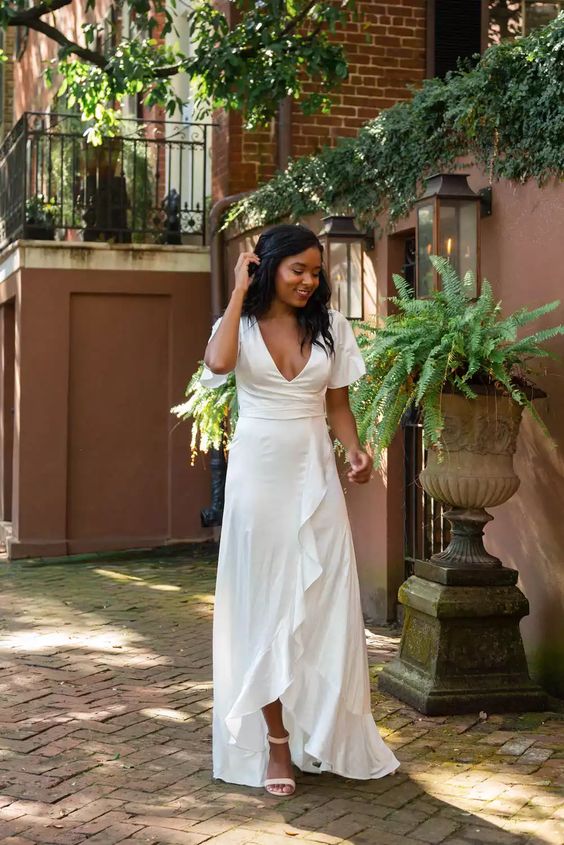 a white maxi dress with a deep neckline and a ruffle skirt plus short sleeves is a great bridal shower solution