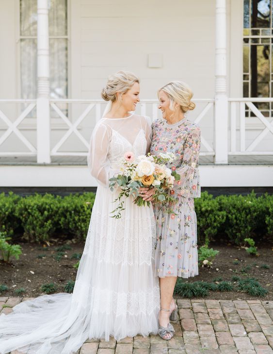 a dreamy and pretty floral embroidery midi dress with a high neckline, bell sleeves, a pleated skirt and bow shoes for the mother of the bride