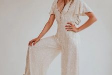 43 a shiny white sequin jumpsuit with a V-neckline, short sleeves, wideleg pants with a train for a bridal party
