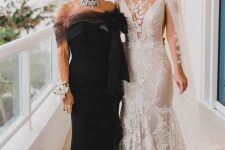 44 a glam and chic black strapless mother of the bride dress with a sheer detail, a large bow, a statement necklace for a wow look