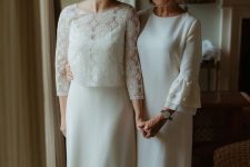 60 an elegant plain white midi dress with a high neckline, bell embellished sleeves and black embellished shoes for the mother of the bride