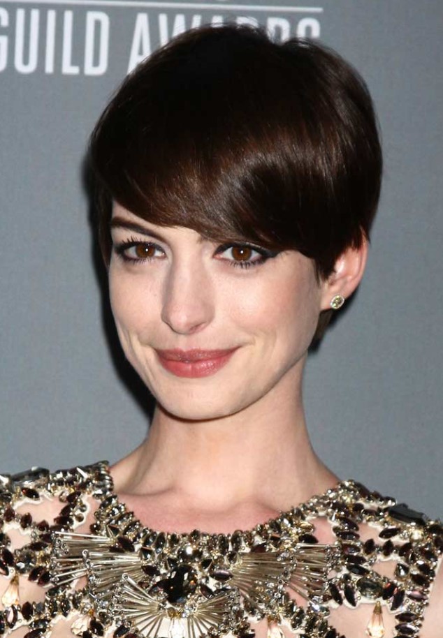 Anna Hathaway wearing a long dark brown pixie that emphasizes the beauty of the face farming it