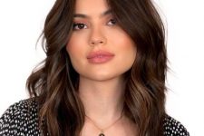 a beautiful layered dark brunette medium-length hairstyle with caramel babylights and waves is amazing