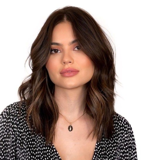 A beautiful layered dark brunette medium length hairstyle with caramel babylights and waves is amazing