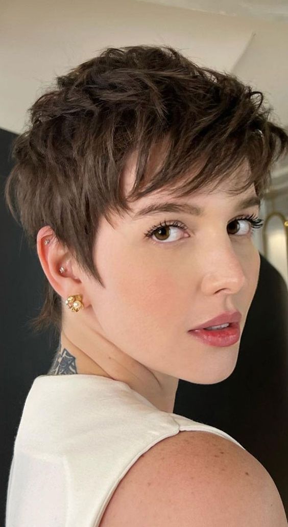 a beautiful layered long brunette pixie haircut with bangs and volume is a chic and stylish idea to rock