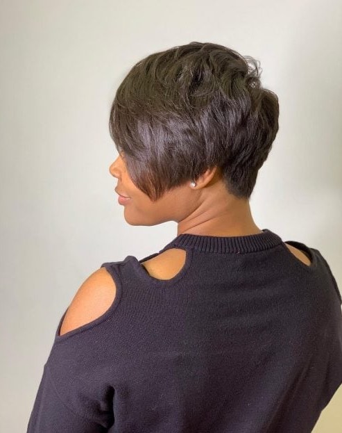 A black long pixie with long side bangs, a lot of layers and the hairline at the back that tapers into a V shape