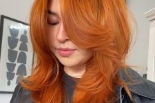 a bold ginger butterfly haircut of medium length, with bottleneck bangs and curled ends is amazing