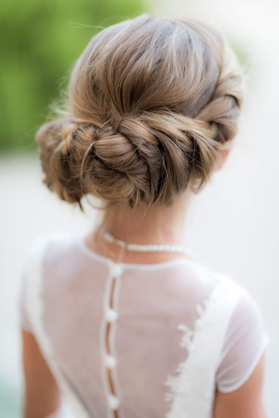 a braided and twisted halo with a bump on top is a cool idea for long and thick hair, great for a flower girl