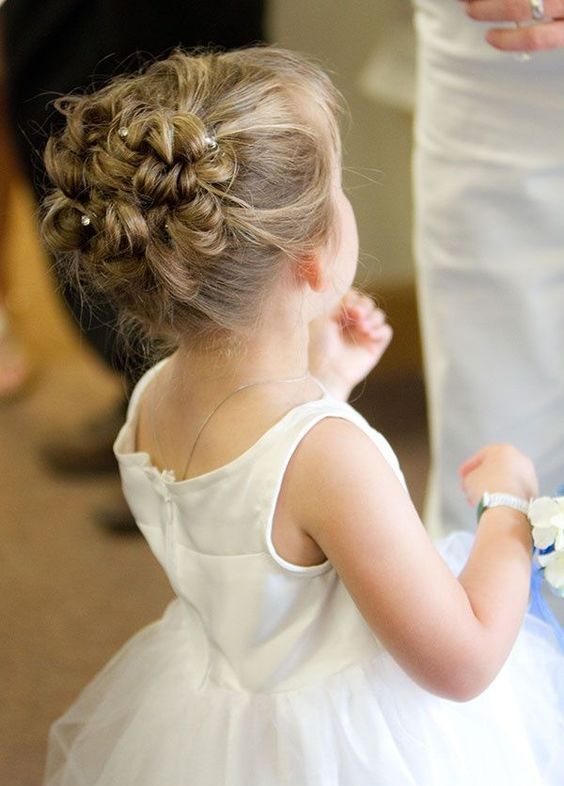 a braided and twisted updo on medium length hair, with rhinestone hairpins is a cute idea for a flower girl