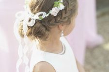 a braided halo and two top knots, with a flower crown plus a bow is a lovely idea for a flower girl