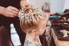 a braided top knot with fresh baby’s breath tucked in is a super cool idea fro a flower girl